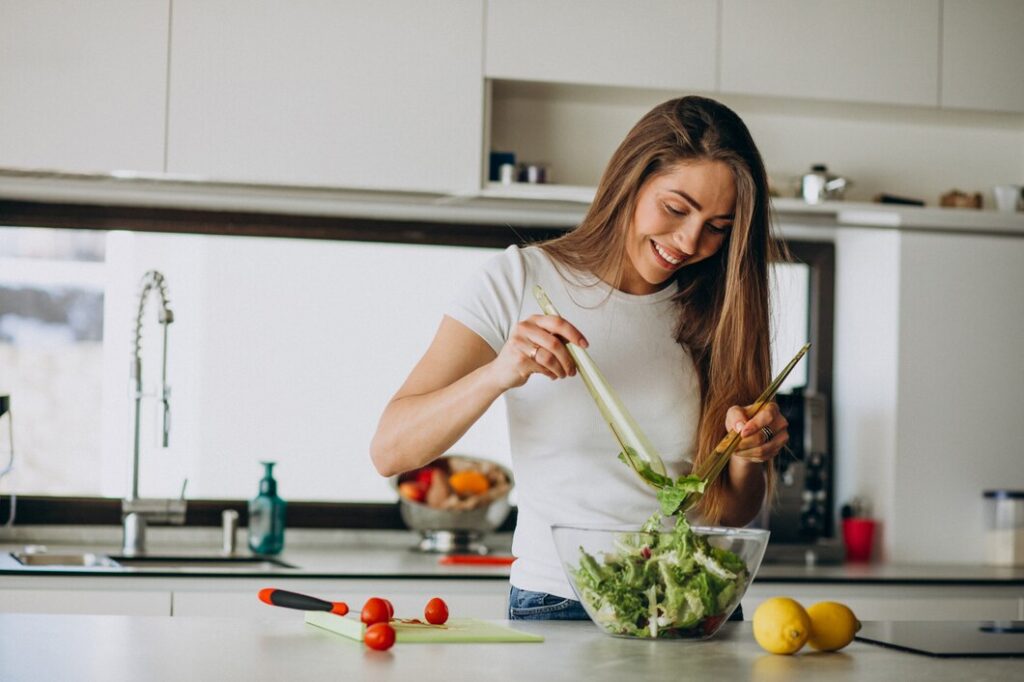 Immagine che ritrae donna che prepara un'insalata.